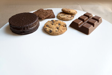Alfajor, chocolinas, galletitas y barra de chocolate. Dulces argentinos sobre base o superficie blanca. 