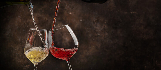 Naklejka premium Pouring whitPouring white and red wine into the glass on rustic dark background. Pour alcohol, winery concept.e and red wine. High quality photo