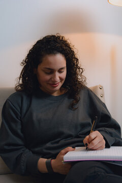 Inspired young Woman writing at home, vertical image.