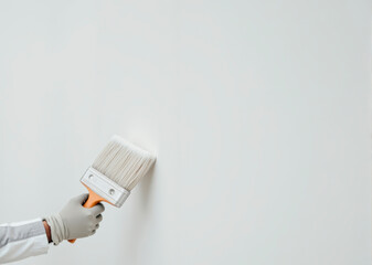 hand holds white paintbrush, gray background, copyspace. Creativity, DIY, Home Improvement concept