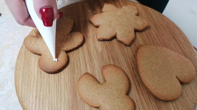Decorating gingerbread cookies for Christmas. Handmade cookie decorating. Family Christmas and New Year traditions. Close-up.