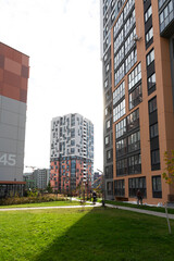 View of modern high-rise apartment buildings in a residential area with green space, showcasing urban living options and property management