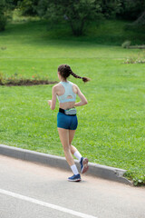 A woman runs on a road with her hair in a braid