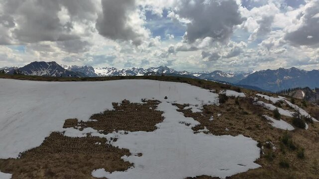 Gebirgspanorma mit Schnee und gr&uuml;nen Fl&auml;chen