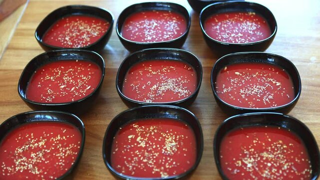 Bowls of freshly made organic tomato soup lined up on a table