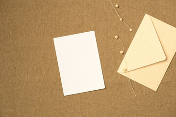 Envelope and paper blank sheet on fabric background from above. Space for text