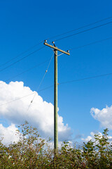Obraz premium An image of a tall wooden power line pole used for the electrical distribution grid in rural areas. 