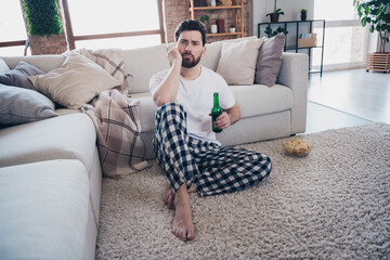 Obraz premium Photo of attractive frustrated man wear pajama sitting on sofa dream think weekend room interior indoors