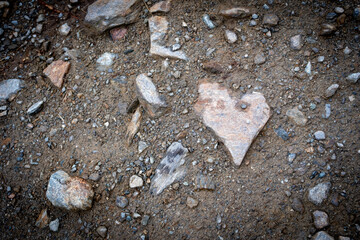 Geröllsteine auf Wanderweg mit grösserem Herzstein 