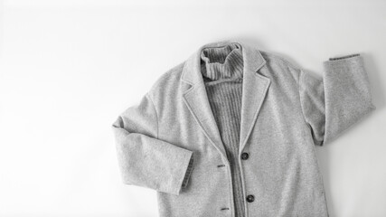 Monochrome look style. Light grey wool coat or jacket and cashmere sweater isolated on neutral...