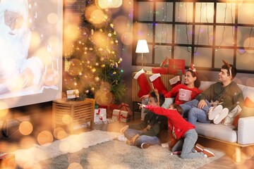 Happy family watching Christmas movie on projector screen at home