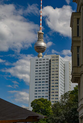 A tall house and behind it Berliner Fernsehturm – The Berlin TV Tower is located in Berlin's...