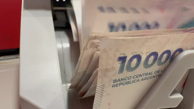 currency counting machine counting argentine 10000 pesos bills. Money counter with pesos banknotes.