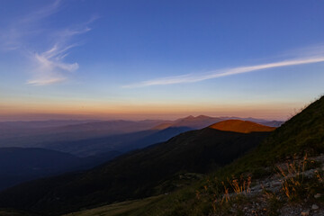 the last rays of the sun before sunset in the mountains, mountain peaks cast shadows on the valleys