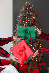 Women exchanging gifts at home on Christmas eve, closeup