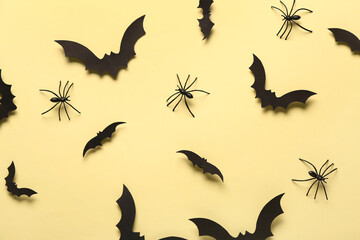 Paper bats and spiders for Halloween party on yellow background