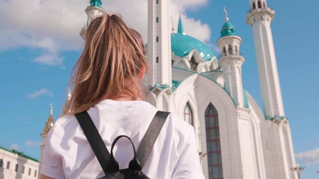 Beautiful tourist girl at kul sharif mosque on a sunny summer day in Kazan, Tatarstan.