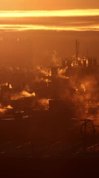 A chilly winter morning dawns, with the sun rising over the rooftops of tall buildings in Russia. The warm air rises from the vents of central heating systems