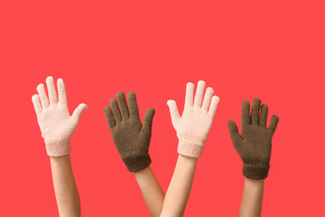 Hands in warm gloves on red background