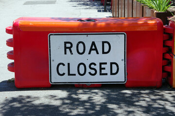 ROAD CLOSED sign on a red road barricade block