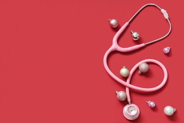 Fototapeta premium Stethoscope with Christmas balls on red background