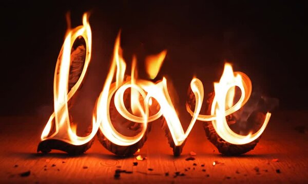  Glowing fiery Love word set ablaze with dancing flames against a dark background, evoking passion and intensity