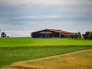 Stroh und Silageballen lagern neben einer Scheune