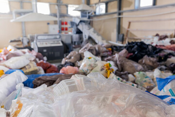 Recycling plant with conveyor belt transports plastic bags garbage recycle into polymer granules for reuse.