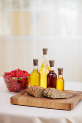 Extra virgin set oil of sunflower, olive in glass bottles, vinaigrette salad and multigrain bread on background of kitchen, eco nature super food
