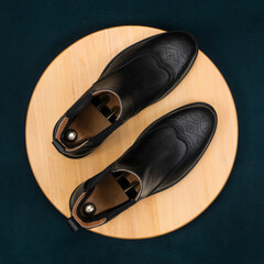 A pair of men's classic shoes made of black leather on a colored background. Elegant fashion for a stylish man