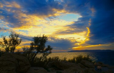 Colorful sunset above the stormy sea and dramatic clouds