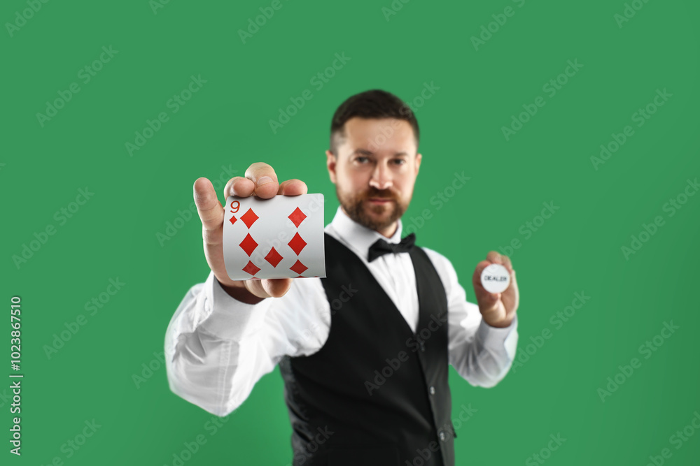 Wall mural Croupier holding card and dealer button on green background, selective focus