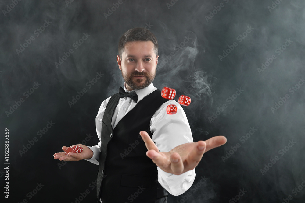 Canvas Prints Professional croupier holding dice and casino chips on black background with smoke