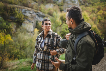 Boyfriend and girlfriend hikers explore forest with mobile phone