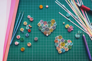 Colored Hearts from colored paper ribbons on Board and paper-cutting tools. Workplace with elements for creating paper art using the quilling technique. Hobby tools and details with paper. 