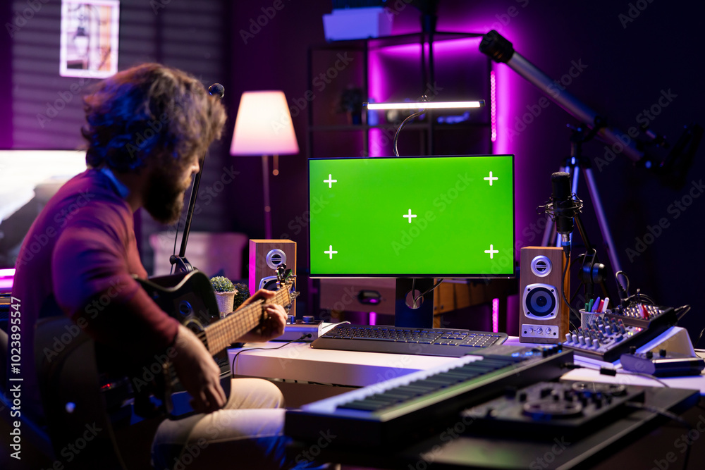 Leinwandbilder beginner guitarist learning to play instrument by watching tutorials online via computer with greens