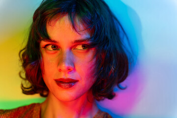 Colorful portrait of a young woman in dynamic multicolored lighting
