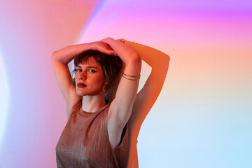 Fashionable woman in ambient light posing thoughtfully