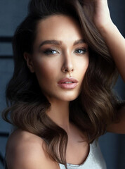 Naklejka premium A beautiful woman with long hair and expertly applied makeup, exuding elegance and confidence in her appearance.