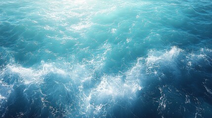 A close-up aerial view of the ocean surface with waves and sunlight reflecting off the water.