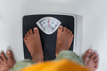 Person Weighing Themselves on a Scale