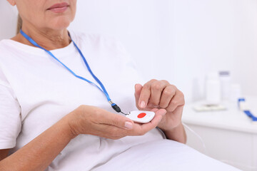 Obraz premium Senior woman with emergency call button on bed in hospital, closeup