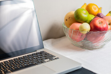 Laptop Next to a Bowl of Fresh Fruits