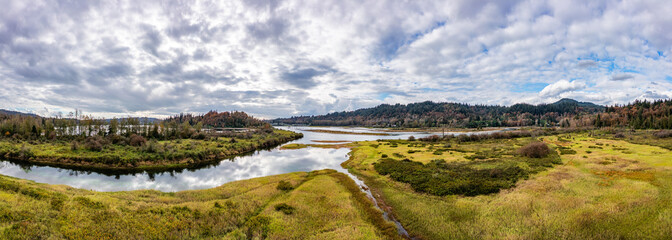 Scenic Landscape of Mission, BC, Canada: Tranquil River Views and Rolling Hills Under a Cloudy Sky