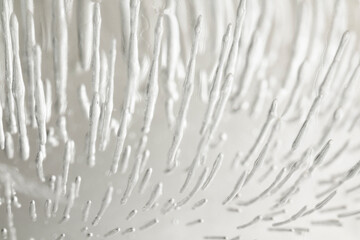 Detail of clear ice cube with cracks and thawing threads inside macro