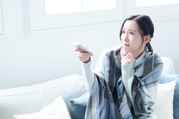 エアコンの温度を調整する女性