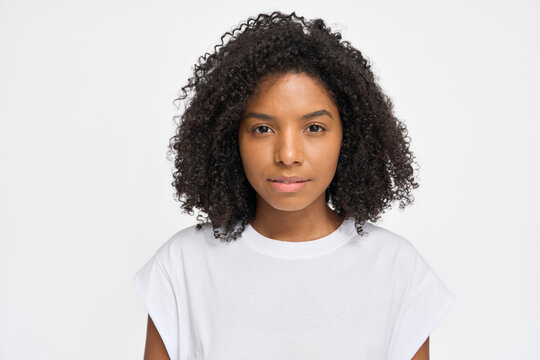 Portrait of young curly pretty cool generation z African woman wearing t-shirt standing isolated on white background. Confident ethnic Afro American female model looking at camera.