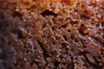 Macro shot of honeycomb cake. The cake is full of tunnels or holes and is quite chewy