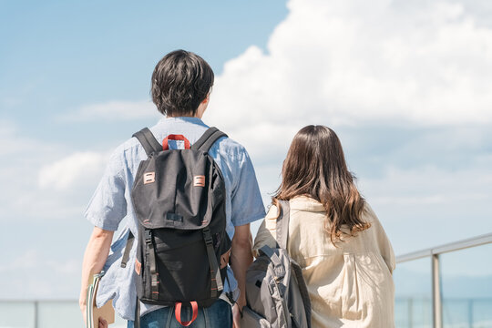 大学・短大・専門学校の校舎・屋上を歩く男女カップル・同級生の学生
