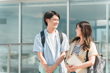 大学・短大・専門学校の校舎・キャンパスを歩く男女カップル・同級生の学生
